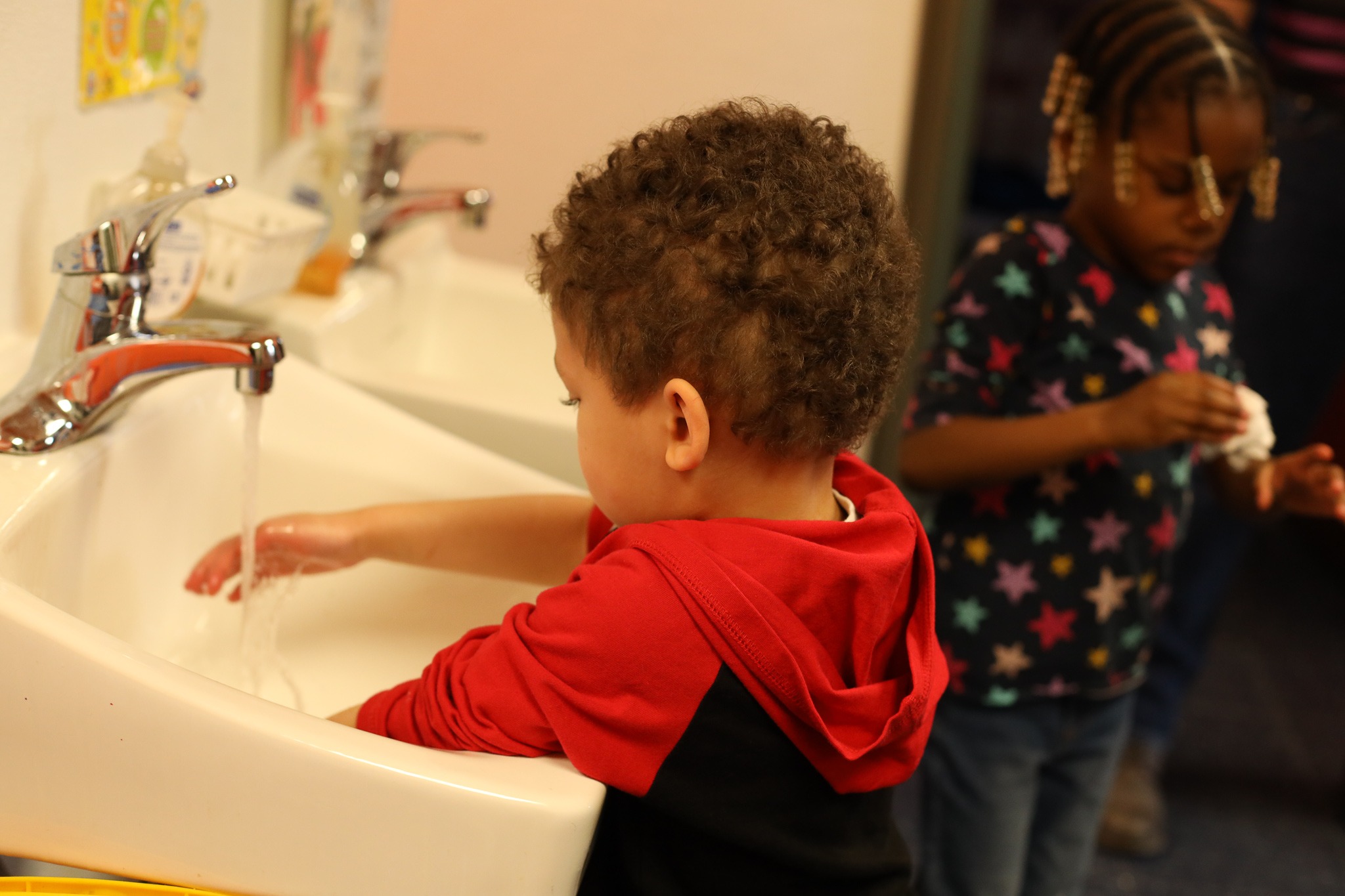 Child washing hands in the sink